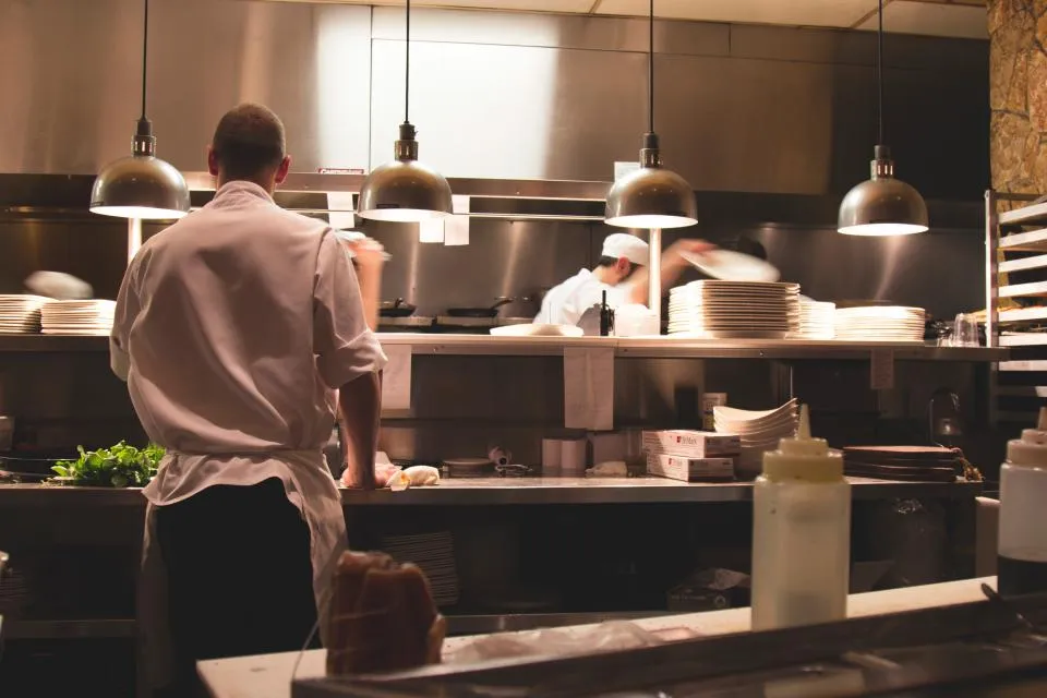 Mesera entregando platillos en la mesa de un restaurante